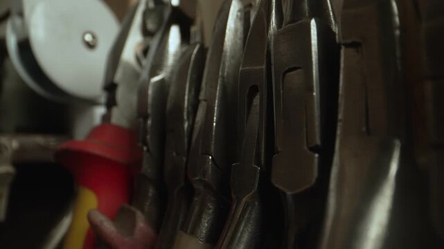 Professional metal pliers and hand tools in row.
