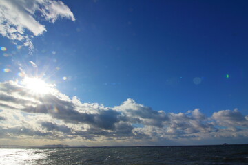 輝く太陽と広がる青空に浮かぶ雲の海景