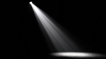 Spotlight Cuts Through Darkness to Create Focused Light in a Dim Space With Shadows Surrounding the Bright Area on the Ground