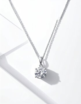 Pendant necklace with sparkling gemstone displayed on a plain white backdrop, studio shot