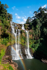 Tad Gneuang is the beautiful waterfall with a rainbow surrounded by rain forest in Southern Laos