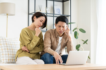 パソコンで悩むミドルの夫婦