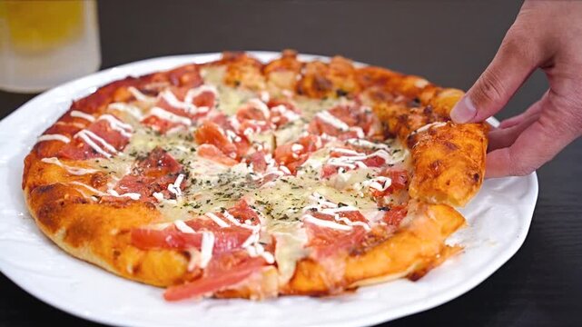 トマトいっぱいピザをもつ男性の手元と生ビール