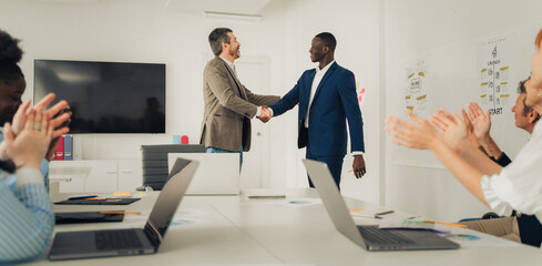 Diverse Business Leaders Shaking Hands for Professional Recognition and Leadership Rewards in Modern Office