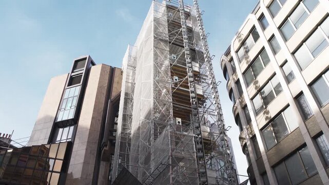 A building covered with scaffolding and protective film during renovation work