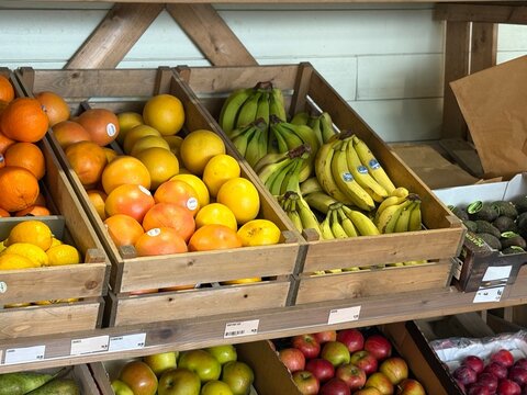 Wooden crates stacked, displaying fresh fruits and vegetables in a farm shop, highlighting local produce, natural colours, healthy food variety abundance!