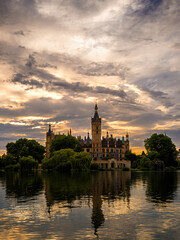 Schwerin Castle reflected in the lake at sunset with dramatic cloudy sky