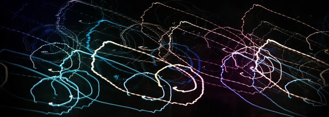 Night photography with selective focus and long exposure. Linear composition in motion. Abstract background, glowing lines. Copy space. Textures of light. Wrapper. Backing. Cover. A unique image.