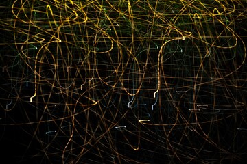 Night photography with selective focus and long exposure. Linear composition in motion. Abstract background, glowing lines. Copy space. Textures of light. Wrapper. Backing. Cover. A unique image.