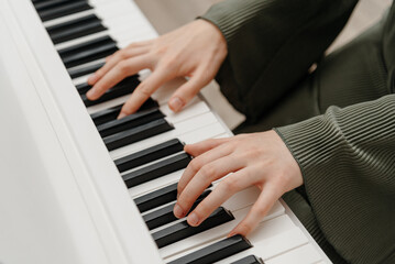 Obraz premium female pianist hands on black and white synthesizer keyboard, close-up view, young woman playing piano, professional musician