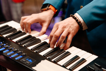 male pianist hands on black and white piano keyboard, close-up view, young man playing piano, professional musician