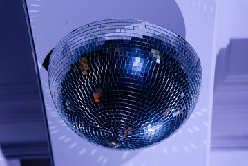 disco ball with mirror surface and bright rays, hemisphere form, hanging on ceiling, night party background