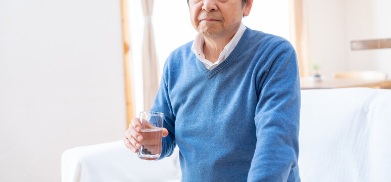 水をまずそうな表情で持つ男性