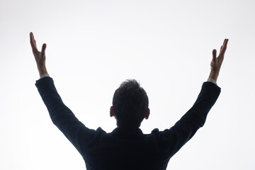 白背景でガッツポーズをする男性のシルエット