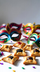 Purim celebration still life with colorful masquerade masks and traditional hamantaschen cookies on bright background
