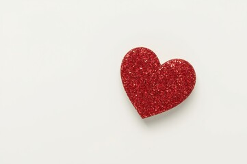 Obraz premium Single red glitter heart on a plain white background