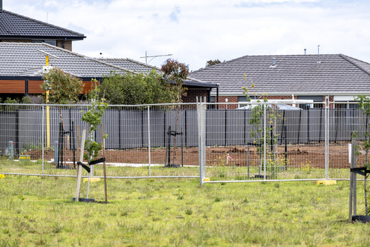 A suburban development site in Tarneit, Melbourne, Australia, featuring temporary metal fencing around vacant land prepared for future housing construction.