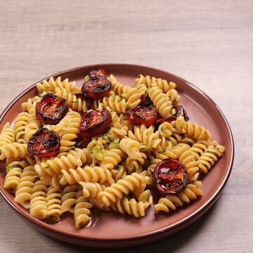 Video quadrato, pasta, fusilli con pomodorini al forno e zucchine, spazio per testo