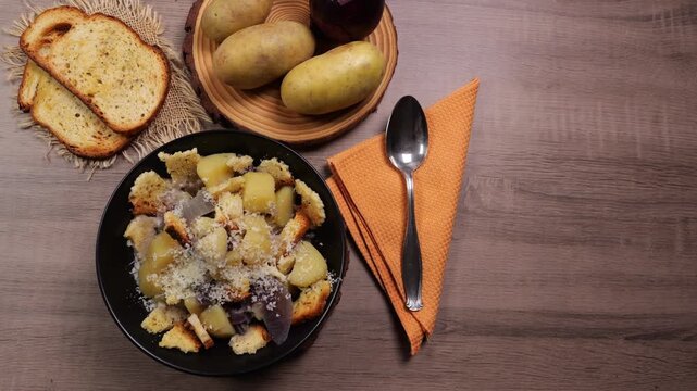 Zuppa di patate e cipolla, con formaggio, e pane tostato, ingredienti sul tagliere