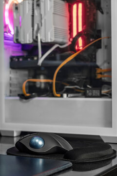 Trackball mouse on desk with gaming pc tower