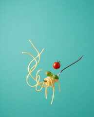 Delicious spaghetti with tomato and basil flying in air