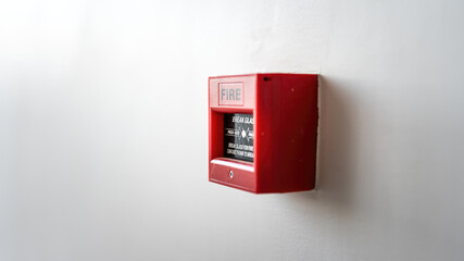 Fire alarm box on white wall, breaking glass and push the button to activate sound alarm. Safety equipment object for building place. Close-up. 