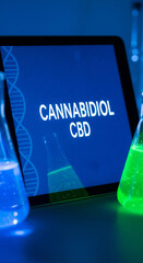 Tablet screen displaying Cannabidiol CBD text surrounded by laboratory flasks with glowing blue and green liquid.