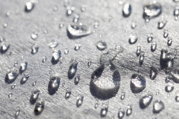 Water droplets on metallic surface with light reflections