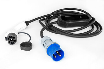 Electric vehicle charger. Thick black cable with Type 2 plug, coiled into a ring, on an isolated white background.
