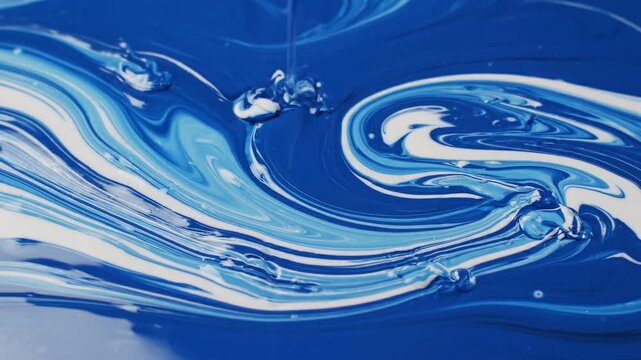 Blue and white acrylic paint swirls together in a fluid motion create an abstract texture for artistic website headers and branding.