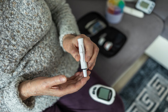 Senior Woman Checking Her Blood Sugar Levels at Home, closeup of hands