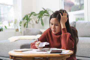Women calculating her income and feeling anxious about paying the due for her debts.