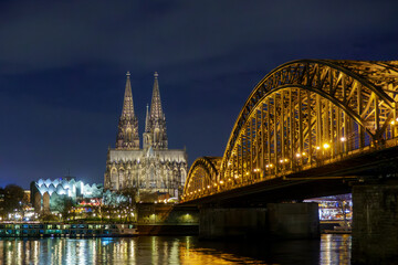 Cologne city skyline panorama at night, Rhine river with illuminated Cologne Cathedral, Great St. Martin Church and Hohenzollern Bridge, Germany