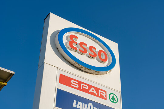 January 24, 2026, Middelburg, Netherlands - Esso, SPAR, and Lavazza logos on a signpost against a clear blue sky