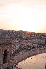 Fototapeta premium View from a stone wall of a city by the sea at sunset