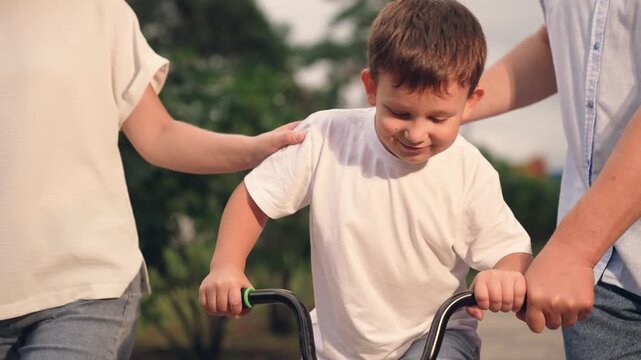 happy family, child riding father mother nature, father teaches child ride bike, family enjoying adventure running, boy laughs smiling sitting bike outdoors, child parent park, father mother teach boy