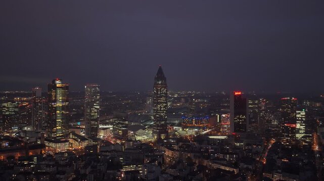 Aerial panorama of Frankfurt am Main skyline at night, showcasing Messeturm and Frankfurt Fair area with pavilions
