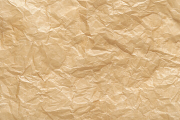Obraz premium Wrinkled brown kraft paper texture with folded creases for background design and crafting projects.