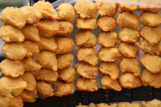 Ram Laddu, a popular Delhi street food made from deep-fried moong dal fritters, being sold in the bustling streets of Chandni Chowk. A vibrant representation of authentic Indian local food culture.