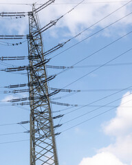 Electricity pylon distributing power lines against blue sky
