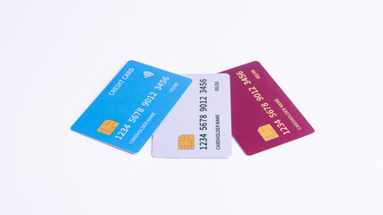 Three Fictional Credit Cards Blue, White, and Red Tilted on White Background

