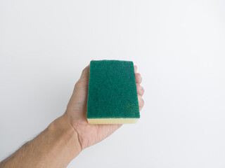 Male hand holding green scouring sponge pad isolated on white background, showing household cleaning tool for dish washing concept.
