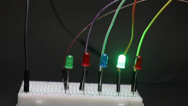 Different color led lights blink in an order that imitates the digital thinking concept. LED lights and the breadboard circuit