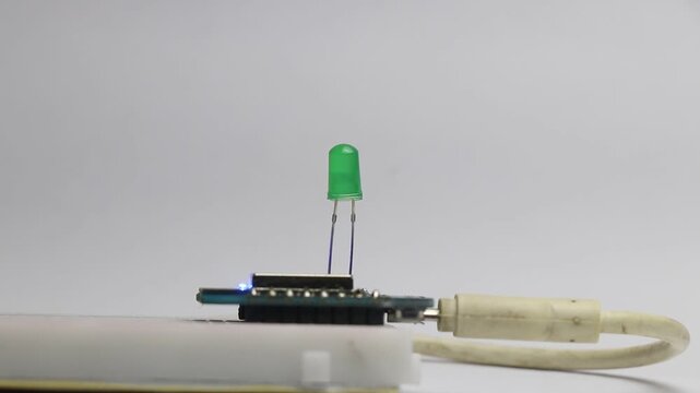 Green color light emitting diode is blinking that is controlled by micro controller board connected to a breadboard