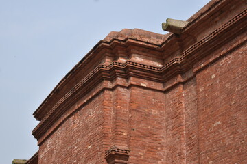 Historic red brick building corner and detailed cornice against sky. © Sulaiman