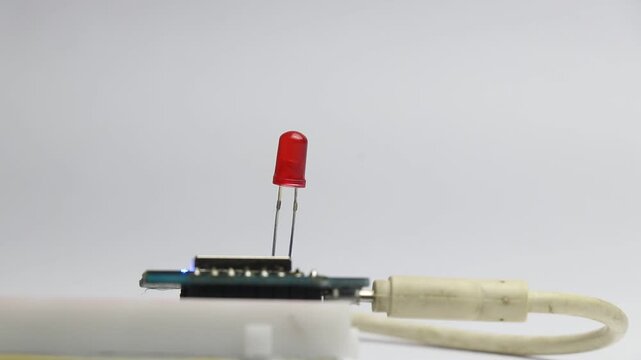 Red color led blinking on a breadboard connected to a microcontroller powered by usb cable