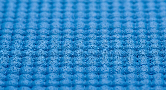 Blue yoga mat foam texture with waffle pattern close up