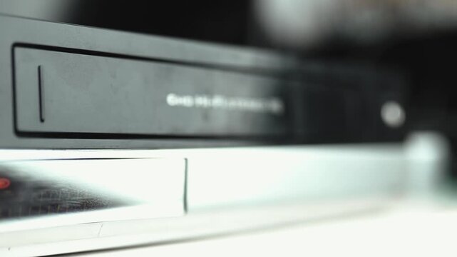 Close up of a hand holding a videotape. Retro vhs cassete in a player.	