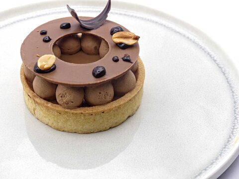 Chocolate tartlet (shortcrust pastry, caramel, chocolate tuile, peanuts)