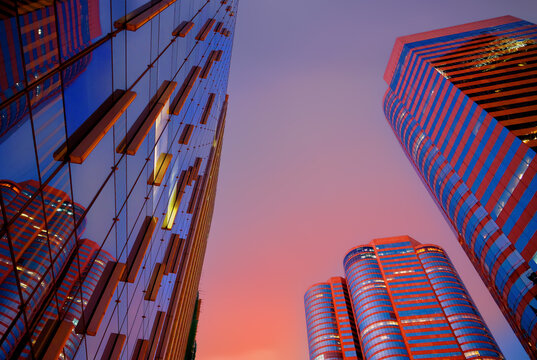 Skyscrapers tower bright glass exteriors sunlight sunset. Facade office buildings. High-rise bank building. Hong Kong Central Business District. Glass facade skyscraper building. HK commercial realty.